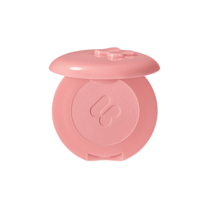 Blush compact from a beauty brand, featuring a pink case with a bow design and soft pink blush inside.