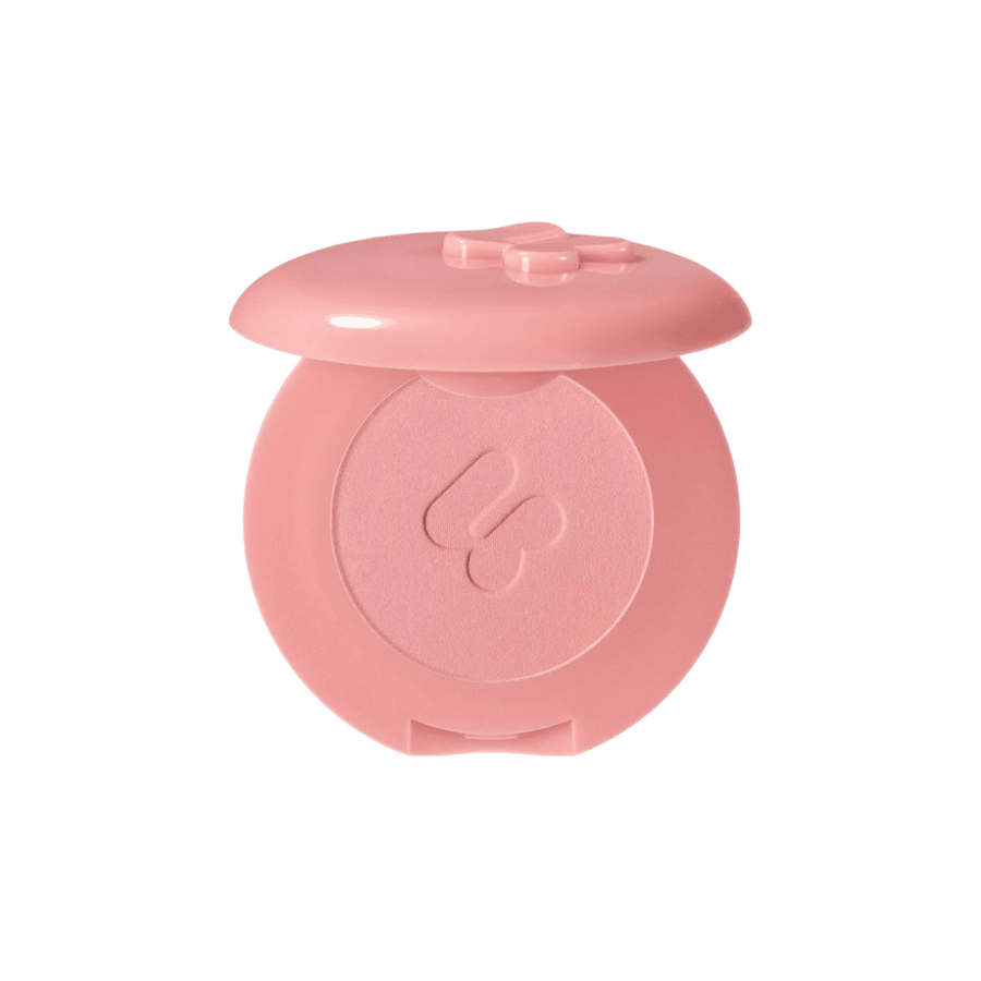 Blush compact from a beauty brand, featuring a pink case with a bow design and soft pink blush inside.