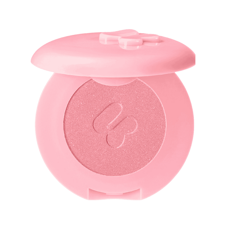 Blush compact with a pink case and a shimmer finish, featuring a bow design.