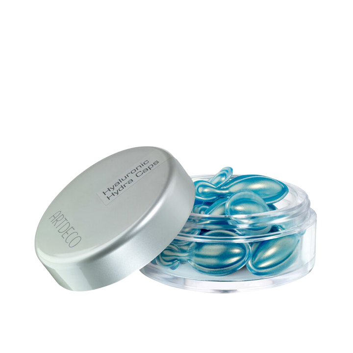 Artdeco Hyaluronic Hydra Caps in a clear jar with a silver lid, containing small blue capsules.