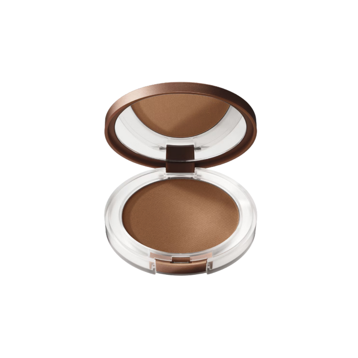 Open compact bronzing powder in clear case with brown lid and mirror, warm tan shade