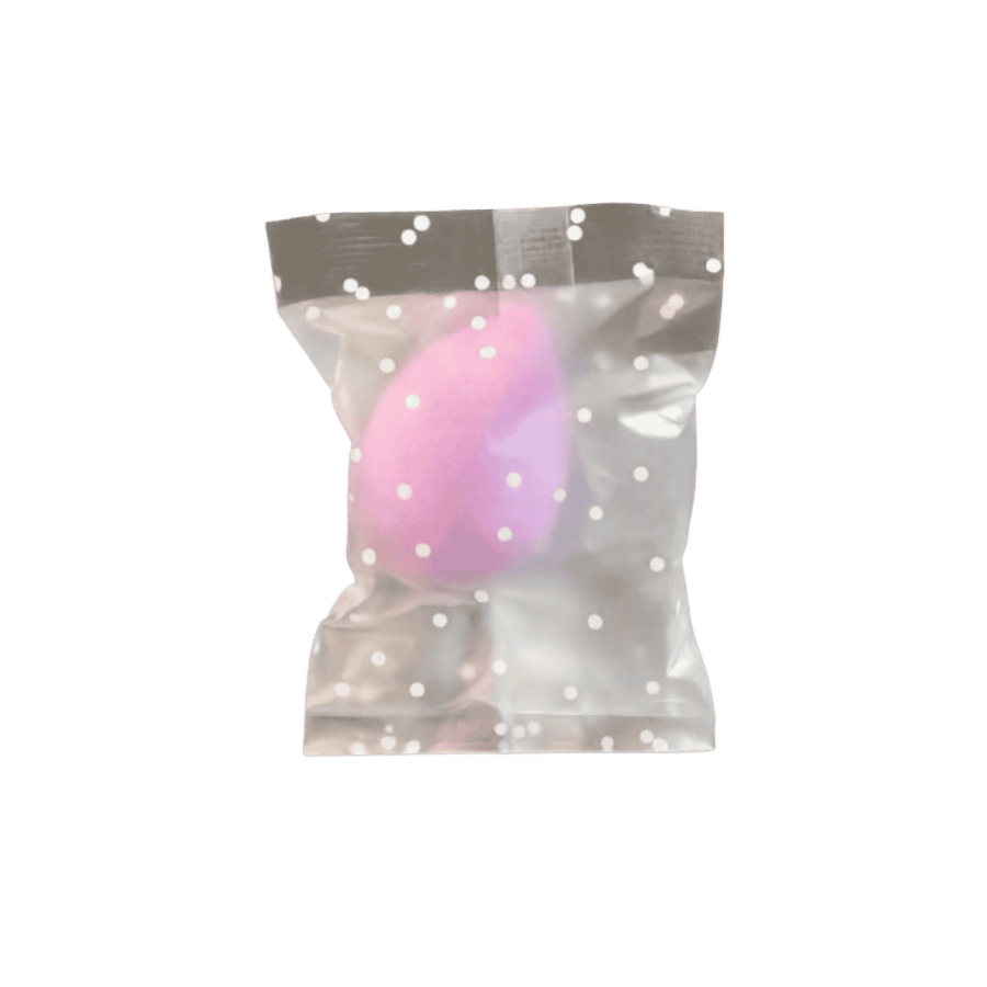 Pink teardrop makeup sponge in translucent gray polka-dot plastic packaging with resealable top.