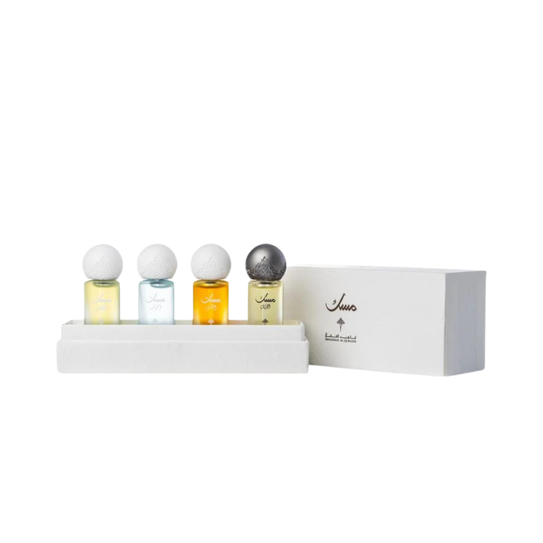 Four musk perfume oil bottles in white box set with decorative caps