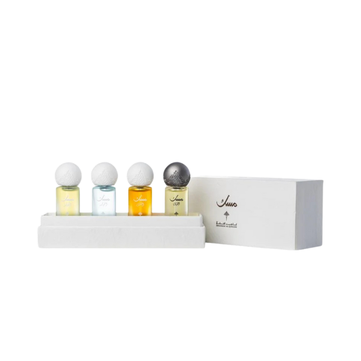 Four musk perfume oil bottles in white box set with decorative caps