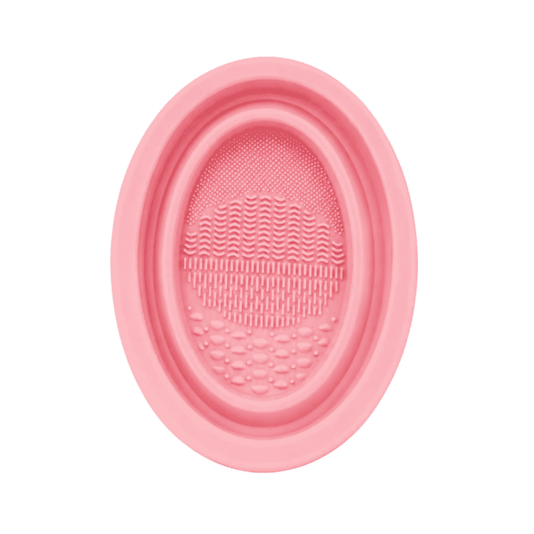 KOHR pink silicone makeup brush cleaning pad with oval shape and multiple textured washing surfaces.