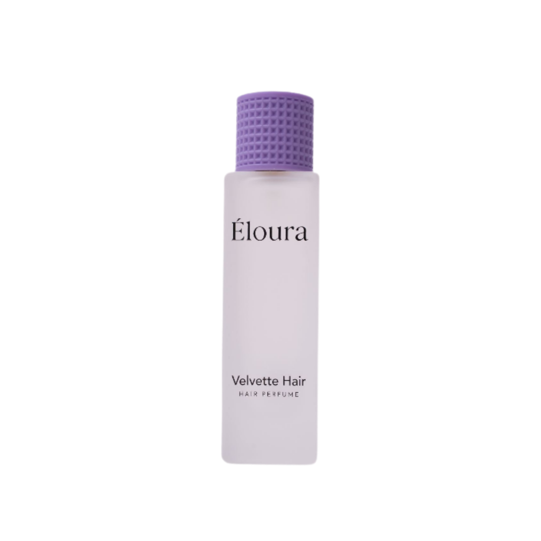 Éloura Velvette Hair Perfume in a frosted white bottle with a textured purple cap.