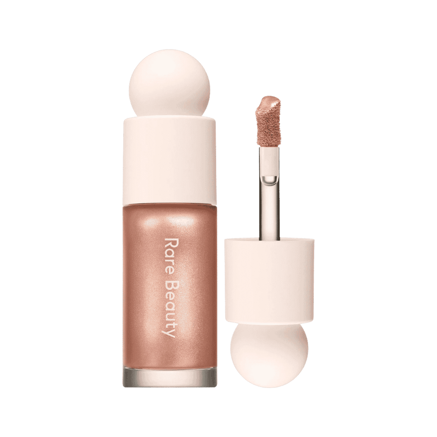 Rare Beauty liquid highlighter in rose gold bottle with pale pink cap and applicator