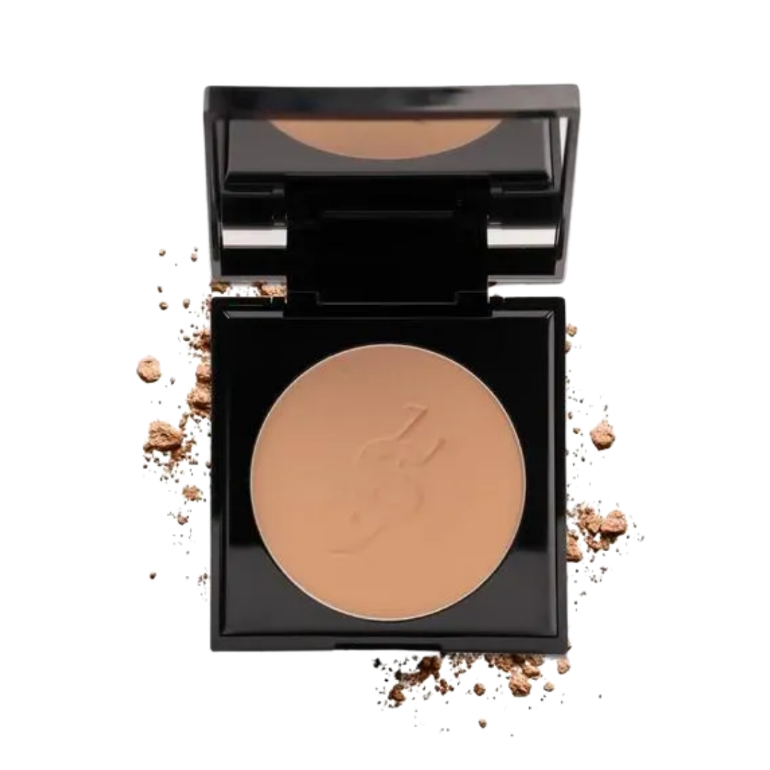 Open black compact with mirror, beige pressed face powder pan, scattered powder crumbs.
