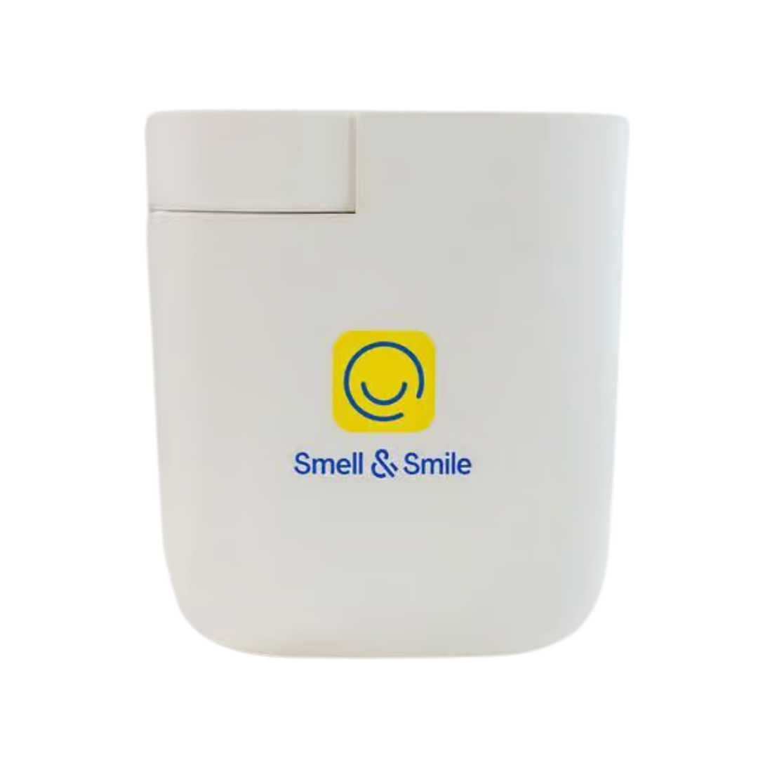 Smell & Smile fragrance device, white rectangular plastic diffuser with flip-top lid, printed logo front.
