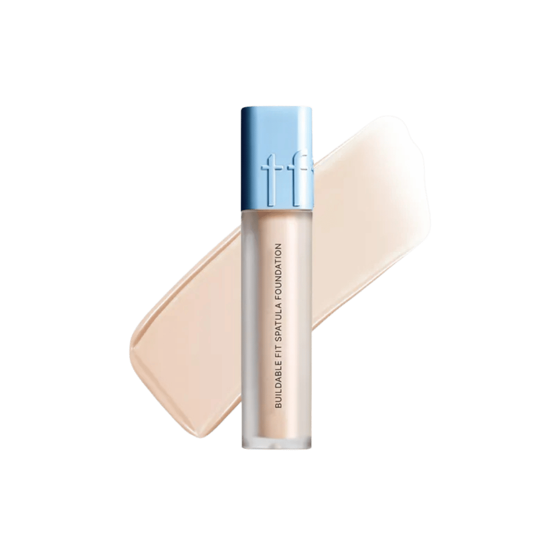 Tfit Buildable Fit Spatula Foundation, frosted cylindrical bottle, blue cap, printed text branding, beige foundation swatch behind, 640x640px 